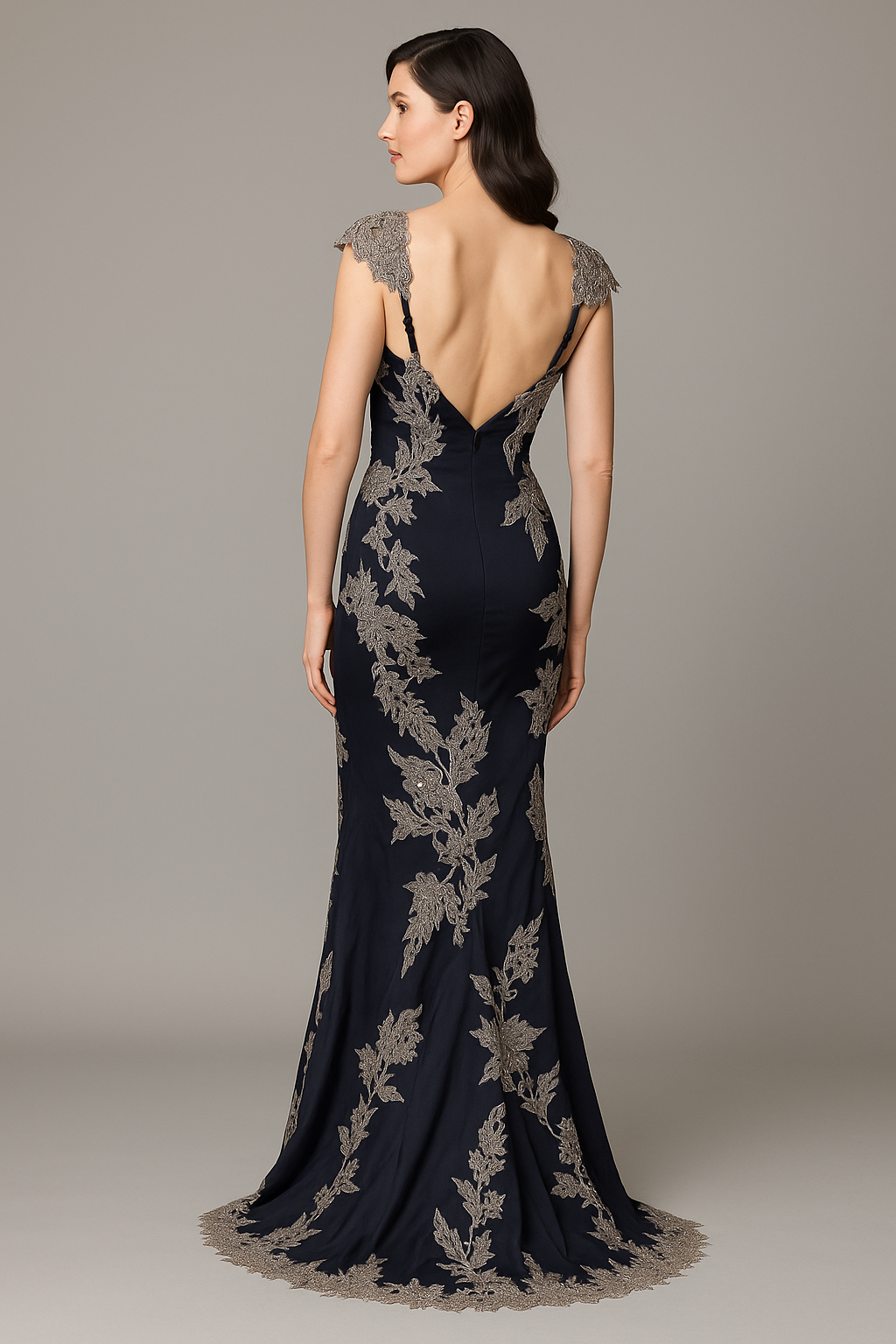 Model wearing Mandalay C831790DEBL sleeveless gown with plunge neckline, embroidered detailing, and open back.  Model is wearing navy.  Back view.