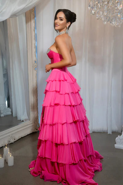 Model wearing Portia & Scarlett PS25961 gown featuring a strapless embellished bodice, sheer corset, high slit, and tiered ruffle skirt.