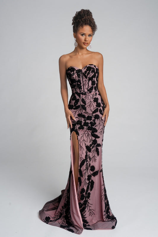 Woman wearing a strapless evening gown with black floral patterns on a white background