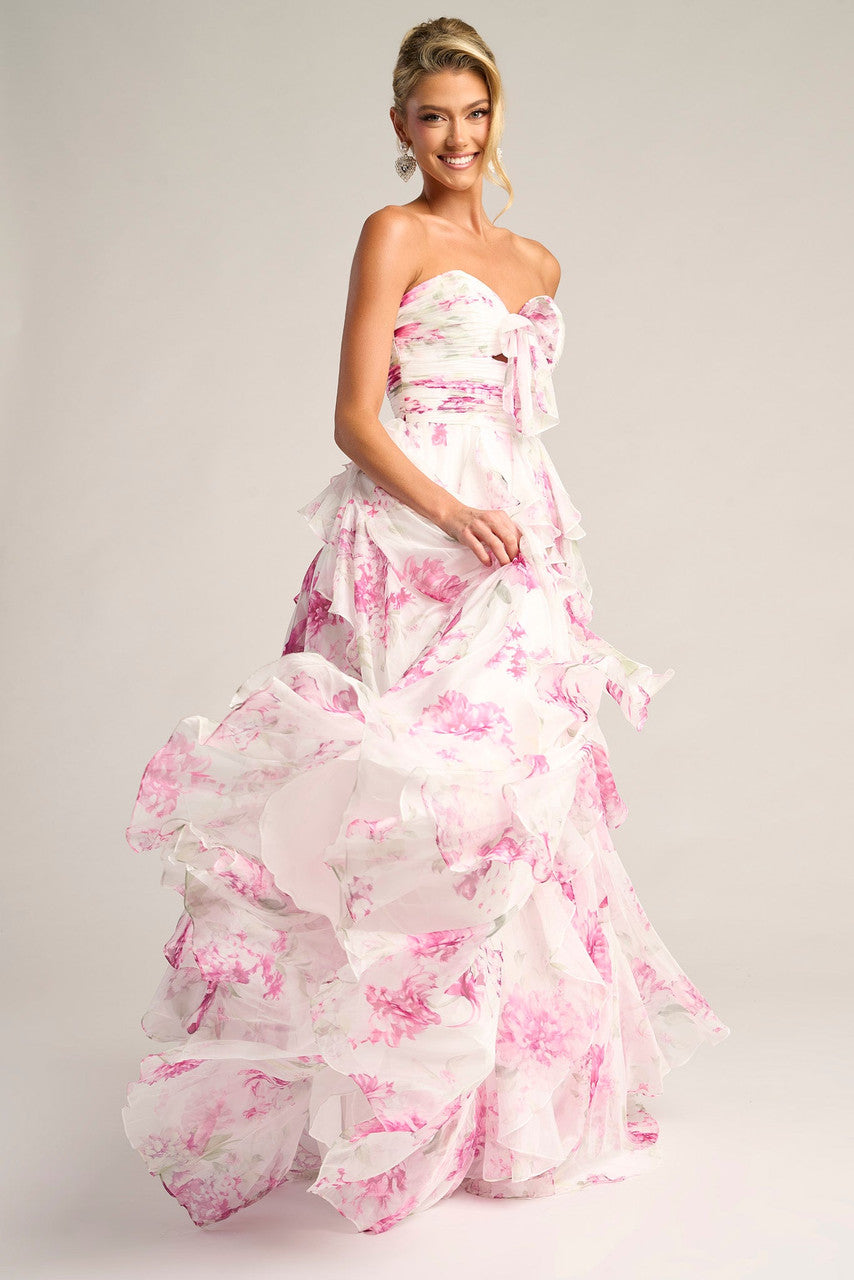 Woman wearing a strapless floral gown on a plain background