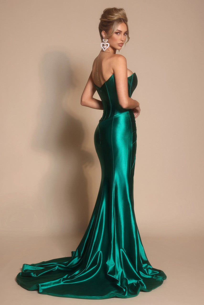 Model wearing Portia & Scarlett XO071 strapless corset gown with a fitted silhouette, draped skirt, and high slit, photographed in a studio setting.  Model is wearing the color emerald.