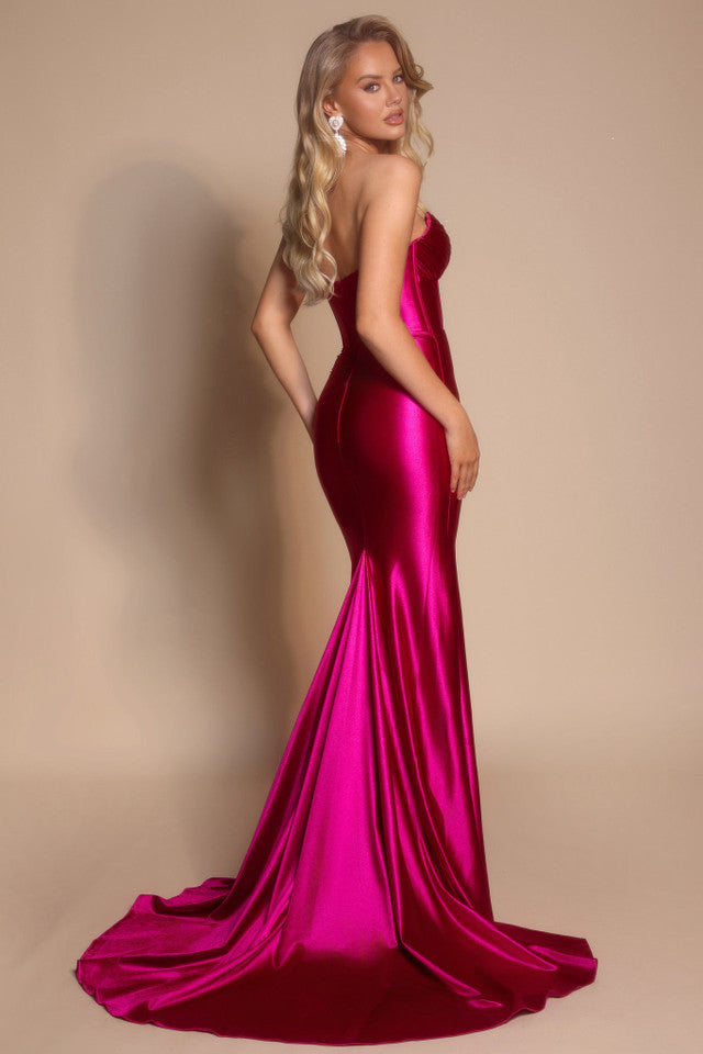 Model wearing the Portia & Scarlett XO080 strapless corset fit-and-flare gown with a structured bodice and floor-length silhouette in the color fuchsia.  Back View.