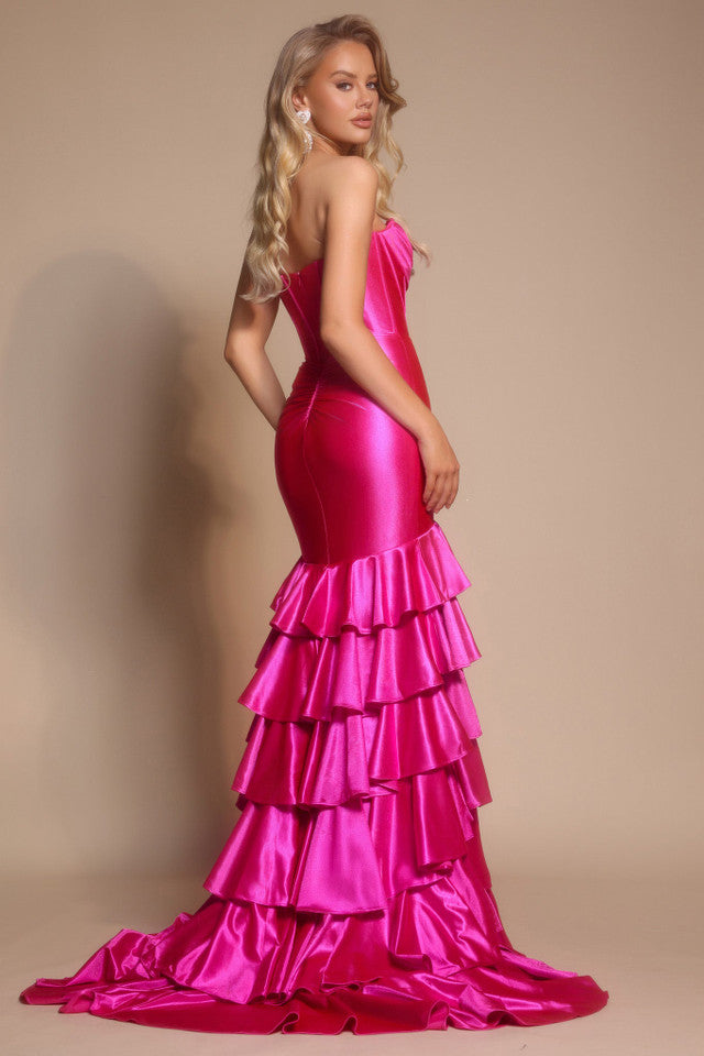 Woman wearing a pink evening gown with ruffled layers on a beige background