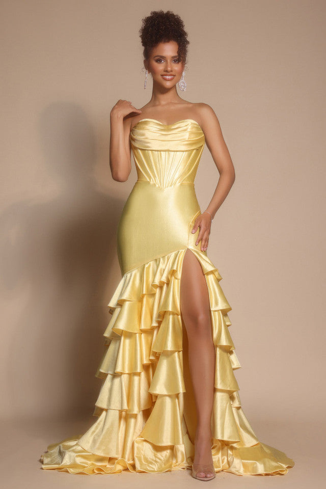 Woman wearing a yellow strapless gown with ruffled skirt on a beige background
