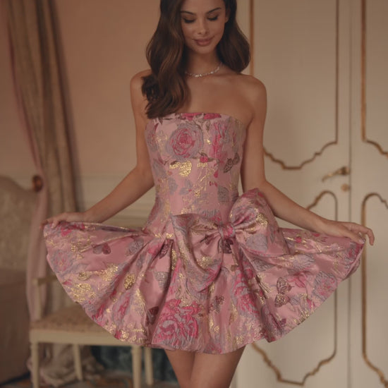 Model wearing Sherri Hill 57468 strapless brocade cocktail dress with drop waist and oversized bow detail.  This is a video of the model wearing the dress.