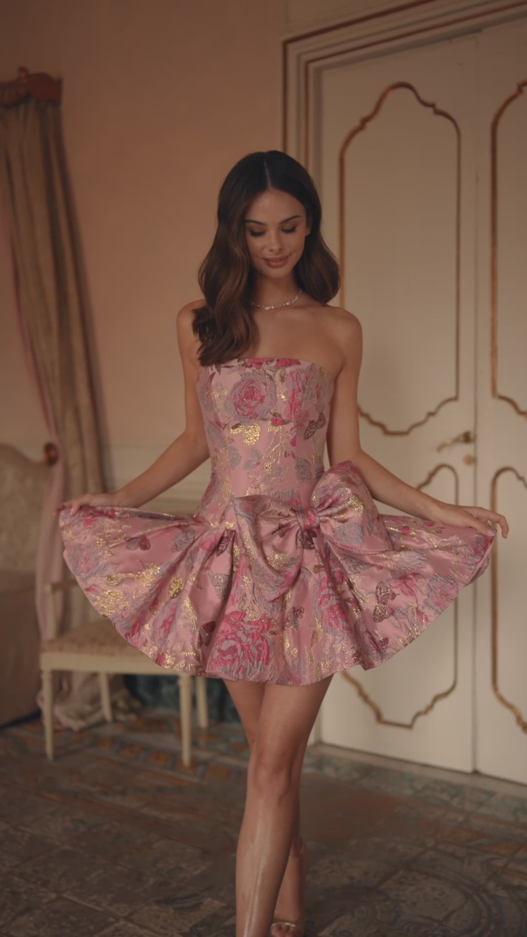 Model wearing Sherri Hill 57468 strapless brocade cocktail dress with drop waist and oversized bow detail.  This is a video of the model wearing the dress.