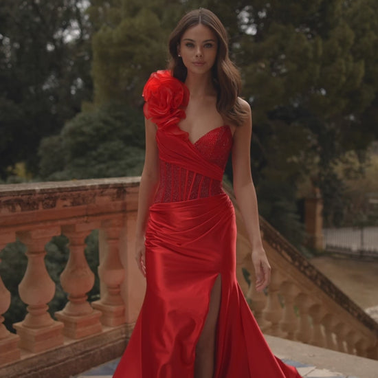 Model wearing Sherri Hill 57475 one-shoulder gown with rosette detail, corset bodice, and draped satin skirt with thigh-high slit.  This is a video.