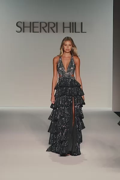 Model walking runway in Sherri Hill 57055 halter A-line gown with ruffled skirt, side cutouts, and shimmering embellishments.  This is a video.