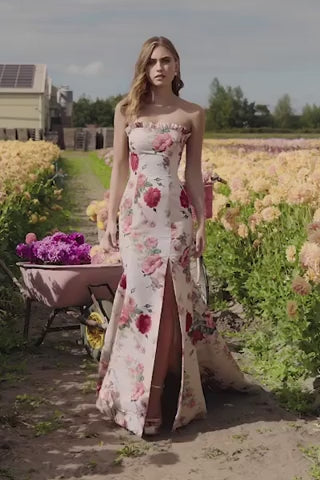 Model wearing SHERRI HILL Style 56283 floral mermaid gown at an outdoor floral setting, showcasing the strapless design and lace-up back.  This is a video of the model wearing the dress.