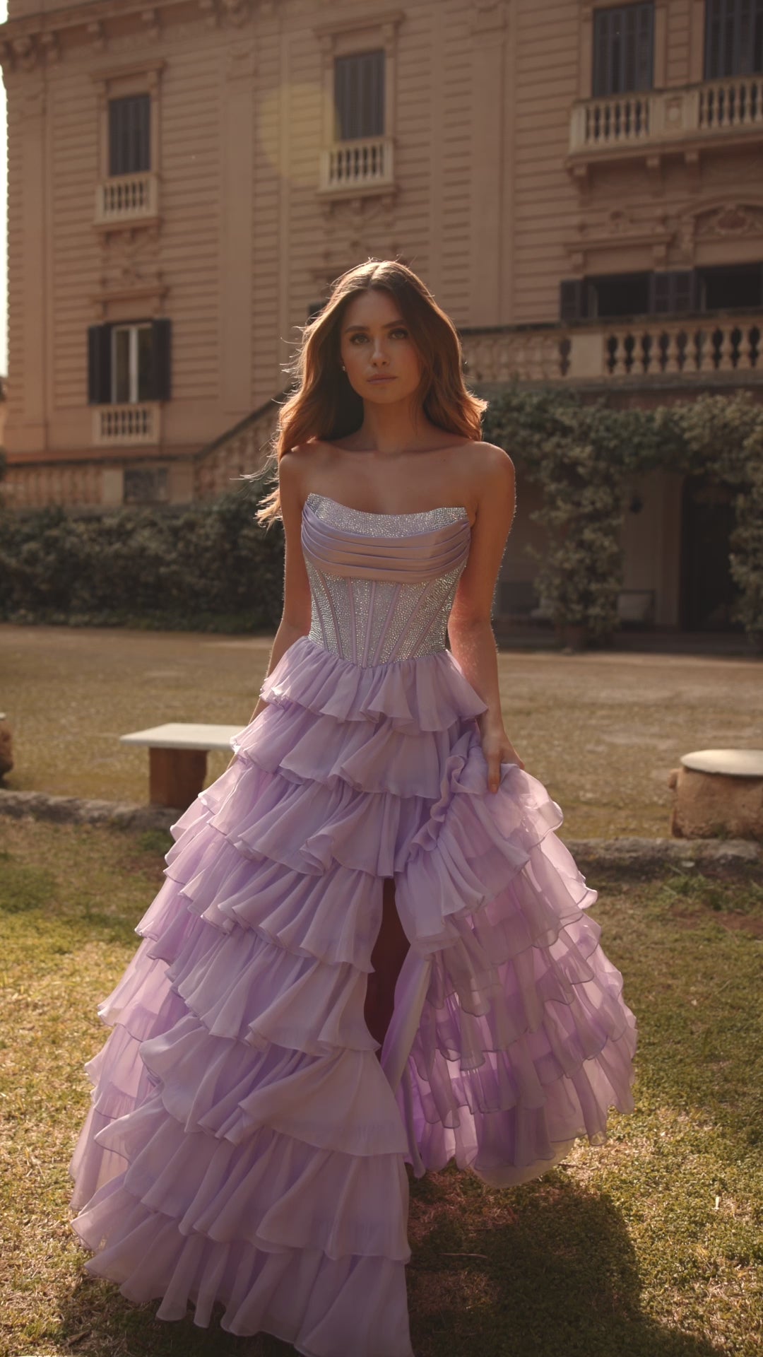 Model wearing Sherri Hill 57288 gown with strapless hot fix corset and layered ruffle slit skirt. This is a video