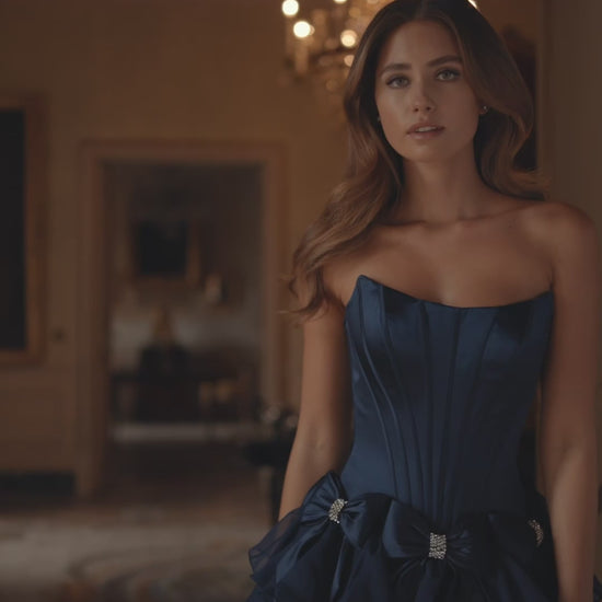 Model wearing Sherri Hill 57276 strapless satin cocktail dress with bow accents on waist and chiffon ruffle skirt.  This is a video of the model wearing the dress.