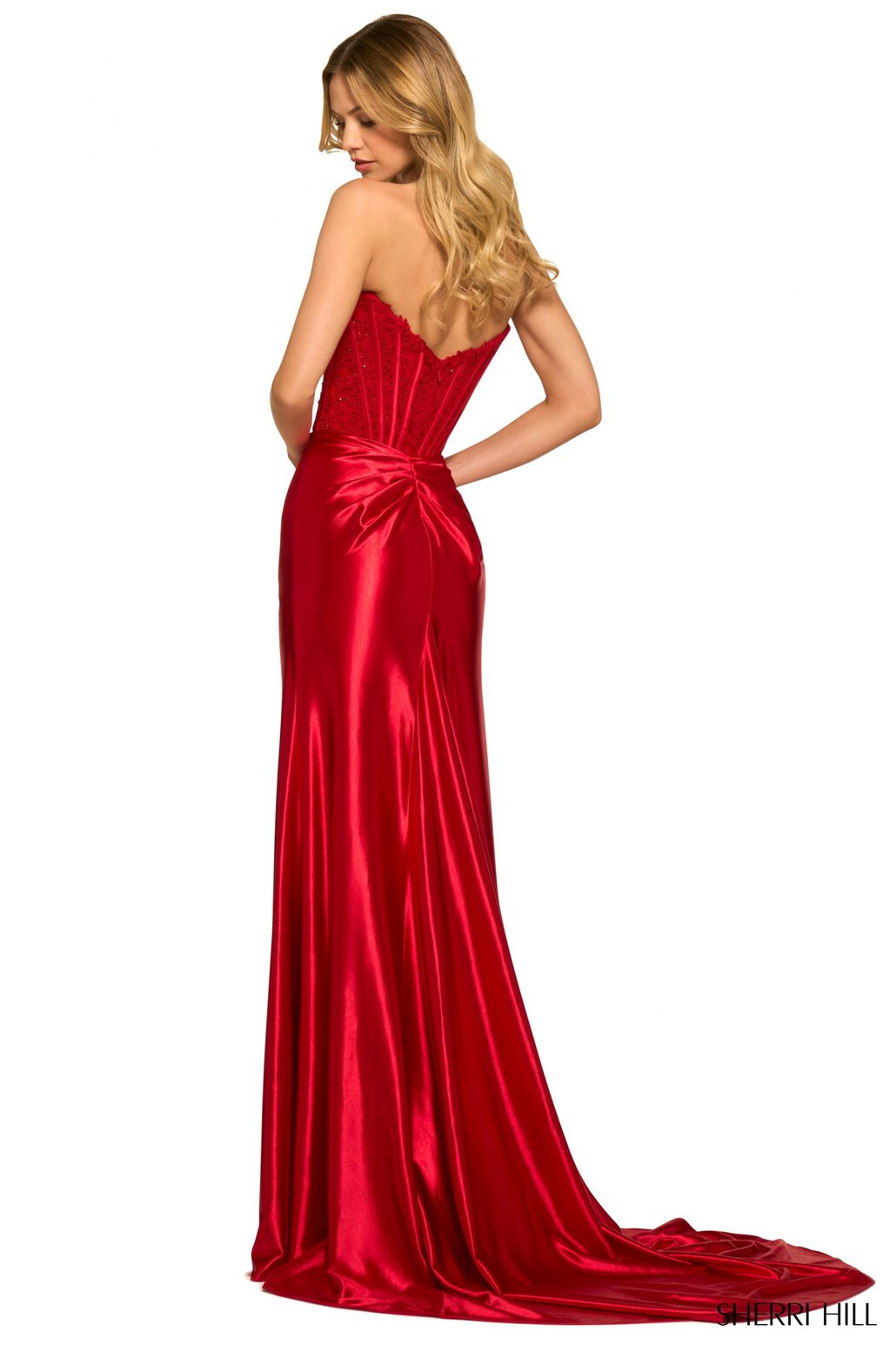 SHERRI HILL 55419 - A strapless satin gown with a lace corset top, high slit, and timeless elegance for a captivating entrance at prom. The model is wearing the dress in the color red.