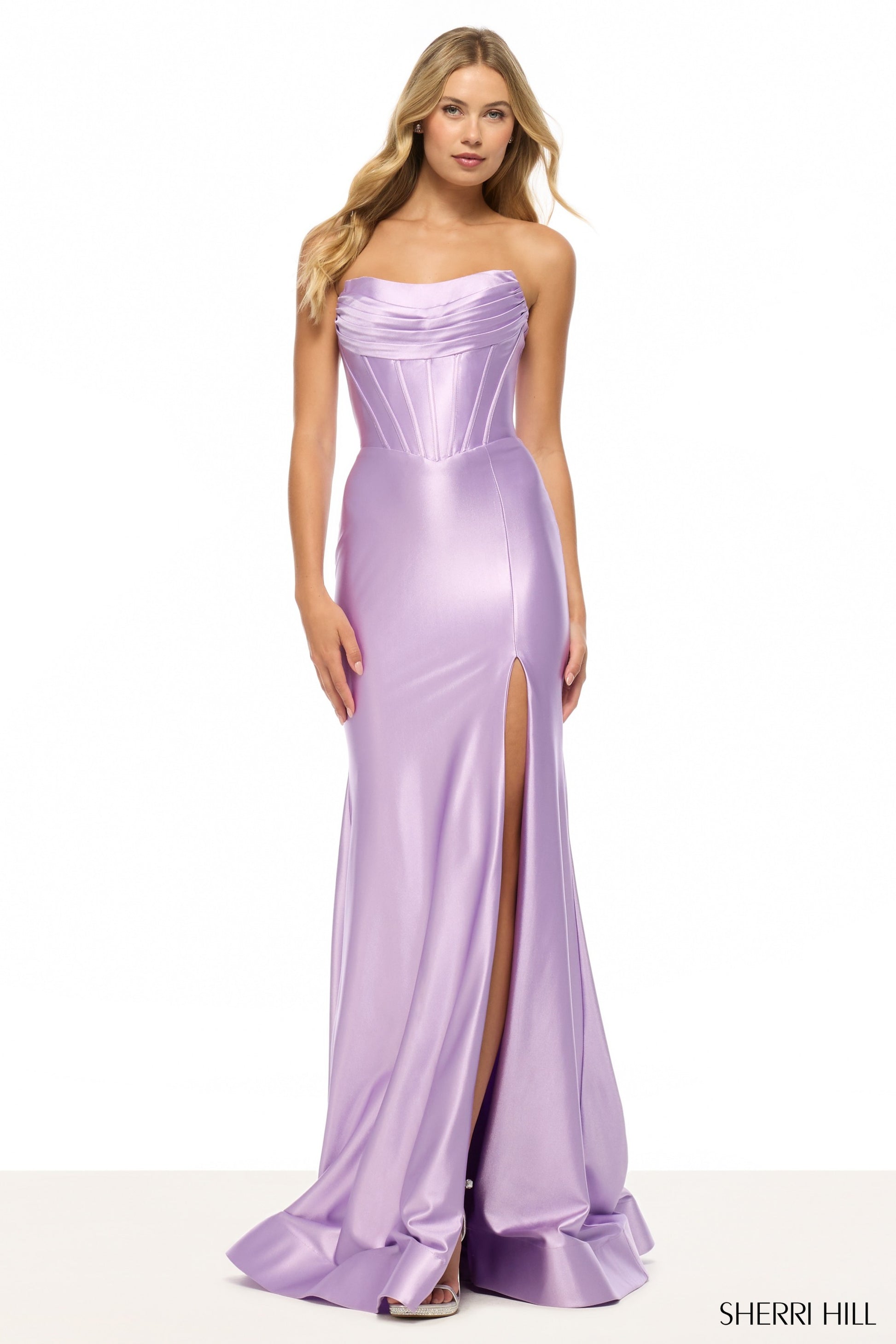 Model wearing Sherri Hill 57412 strapless draped corset gown with high slit and lace-up back.
