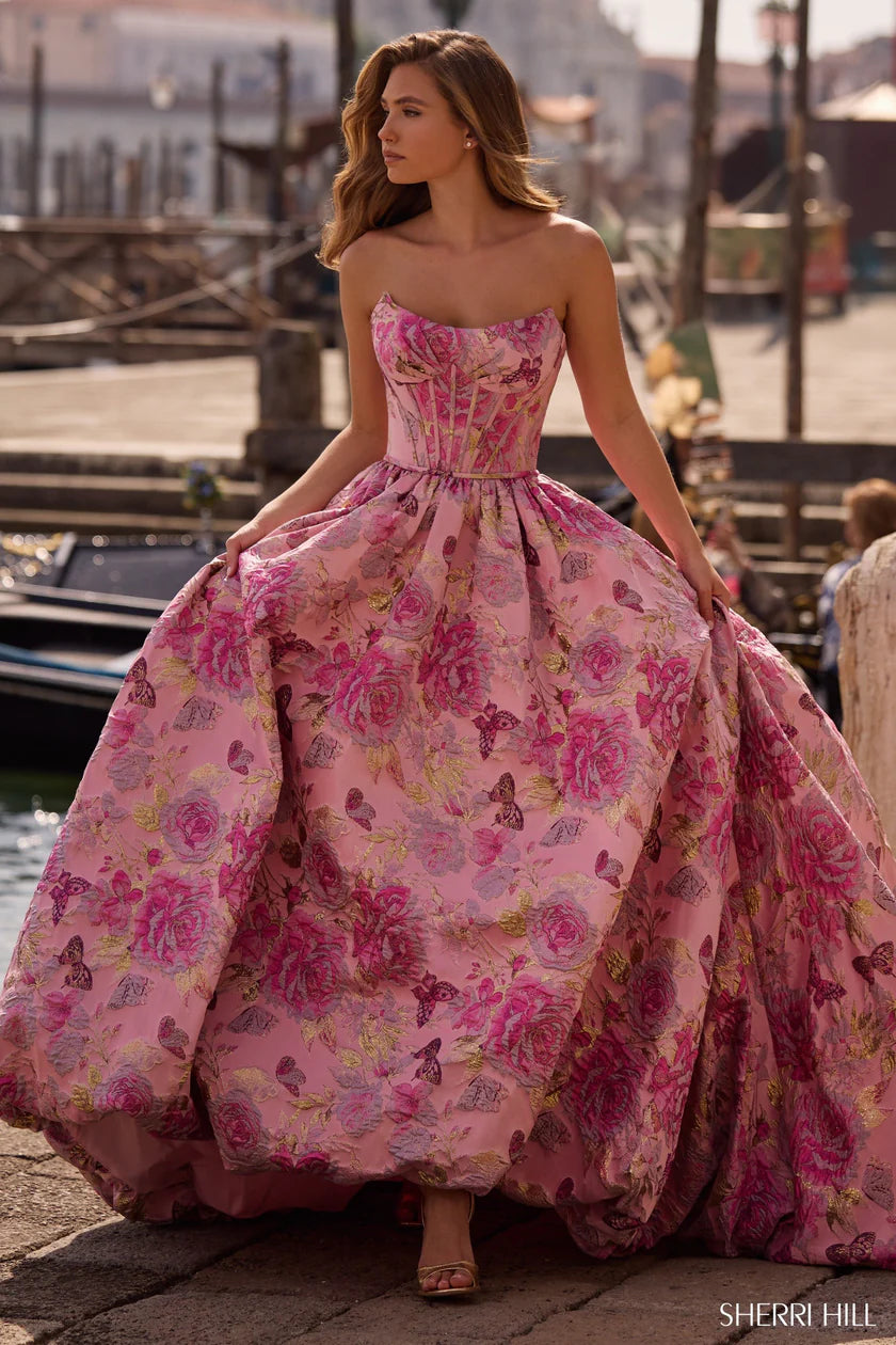 Woman wearing a pink floral dress with a waterfront background