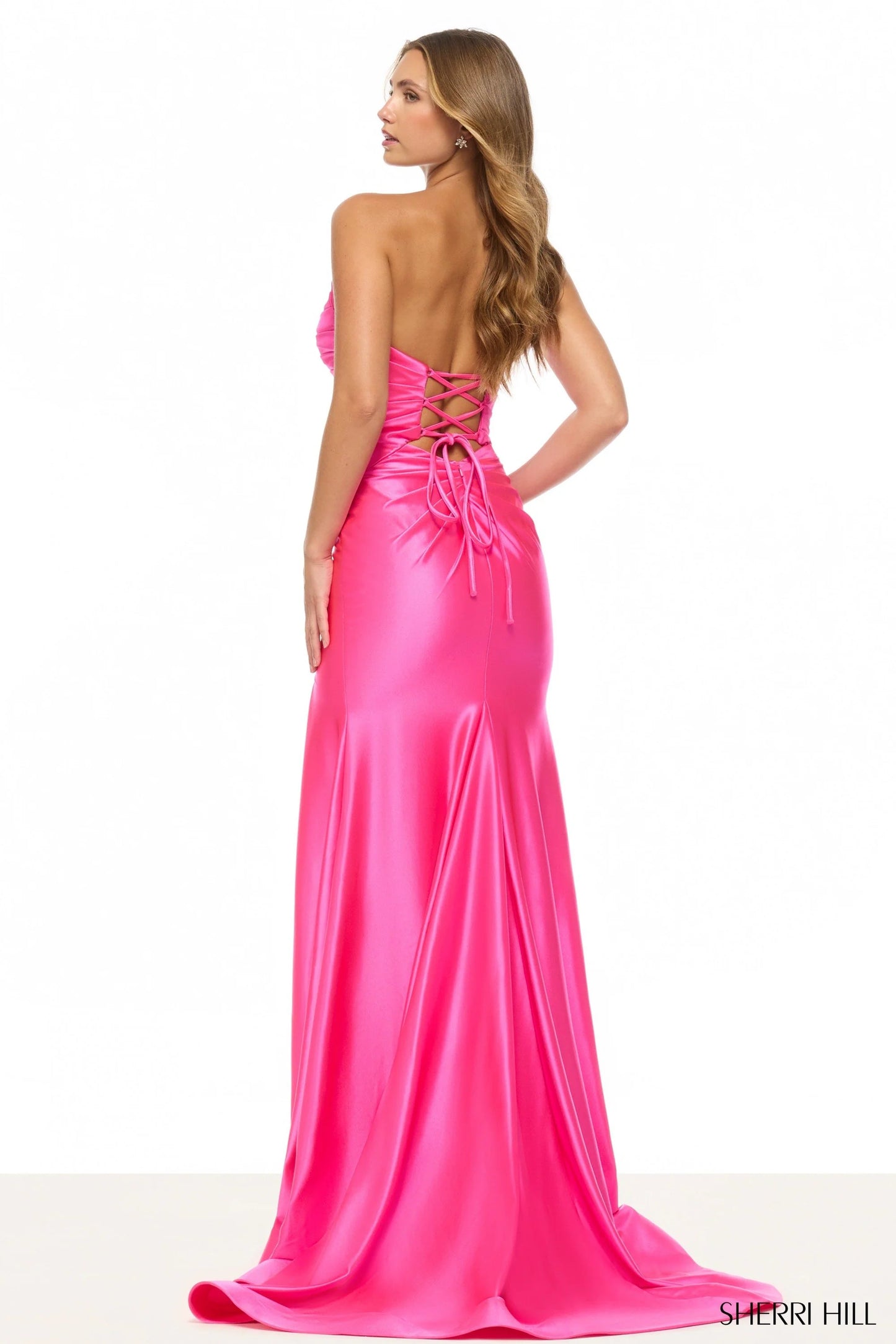 Pink evening gown with open back on a white background, Sherry Hill brand visible.