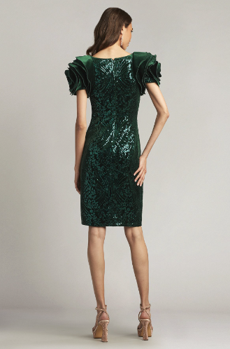 A woman wearing a close-fitting velvet sheath dress with oversized rosette sleeves and intricate paillette embroidery, perfect for elegant evening occasions.