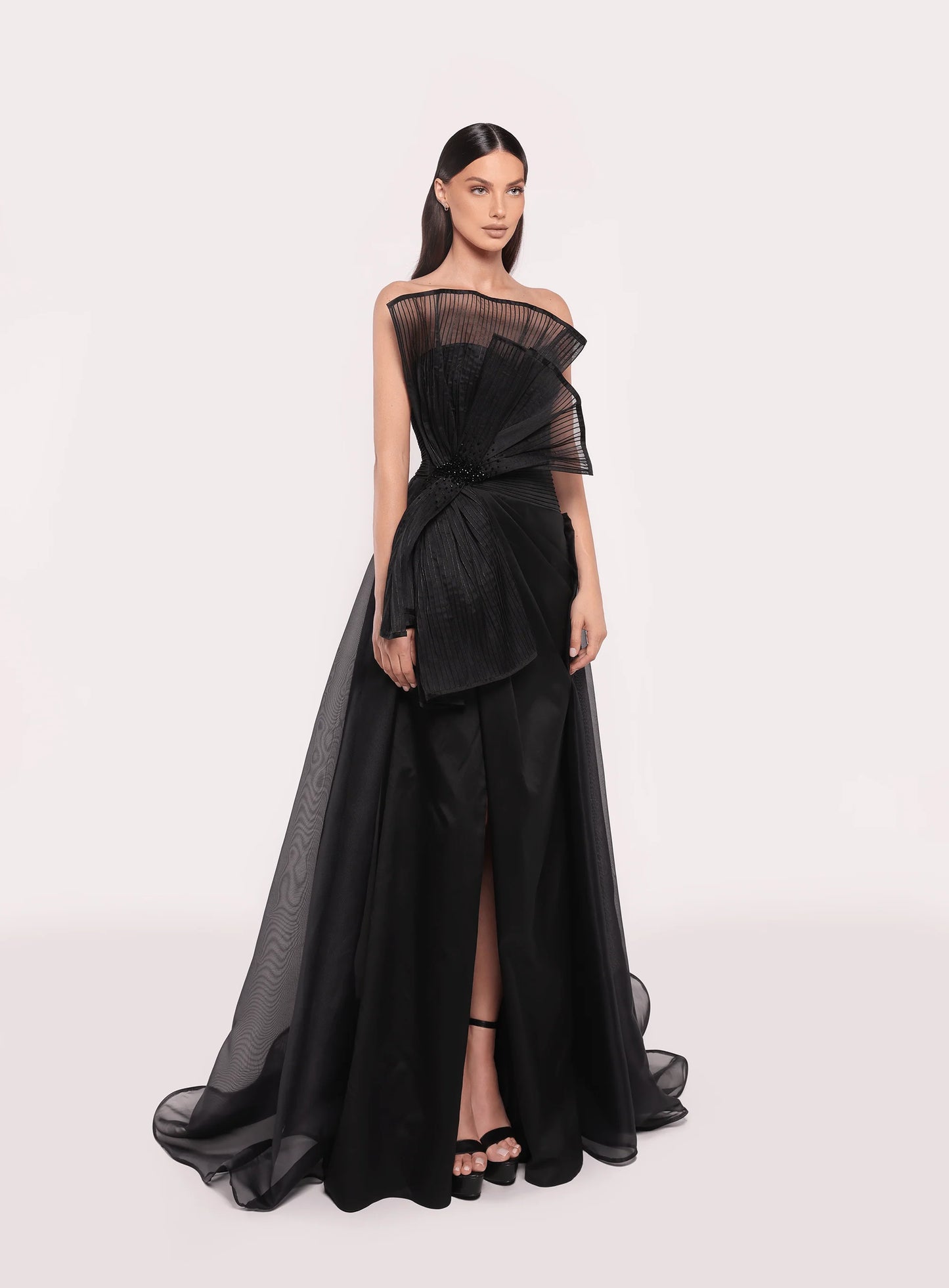 Model wearing Tarik Ediz 98708 Ronesme strapless gown with sculptural pleated bodice and full A-line skirt with train, ideal for red carpet or formal events.