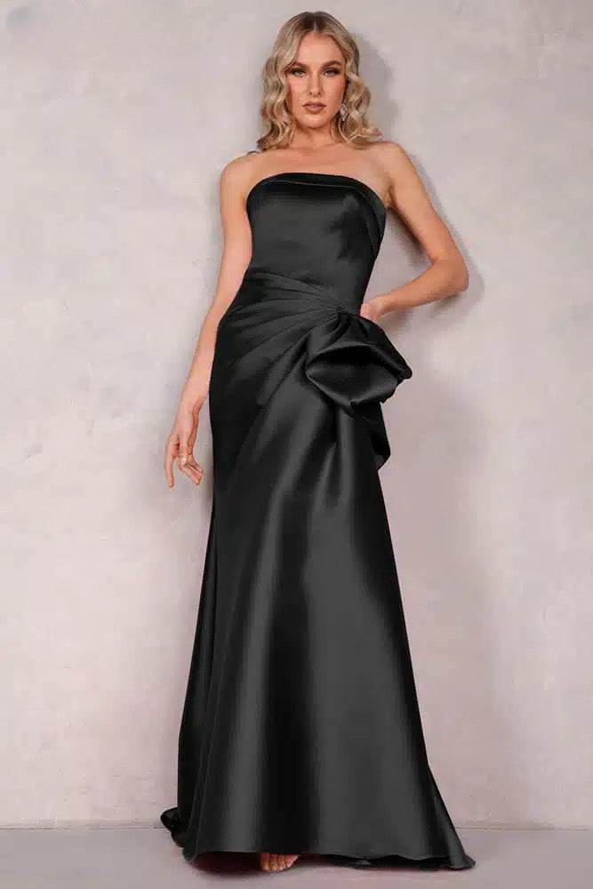 A stunning Mikado evening dress by Terani with an off-shoulder neckline, open back, and a draped bow feature on the waist. Perfect for evening events and as a mother-of-the-bride or mother-of-the-groom dress.