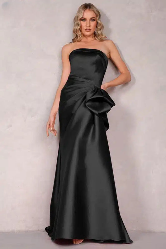 A stunning Mikado evening dress by Terani with an off-shoulder neckline, open back, and a draped bow feature on the waist. Perfect for evening events and as a mother-of-the-bride or mother-of-the-groom dress.