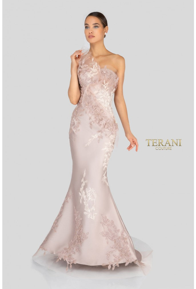 Woman wearing a elegant one-shoulder gown with floral details on a white background, branded 'Terani'.