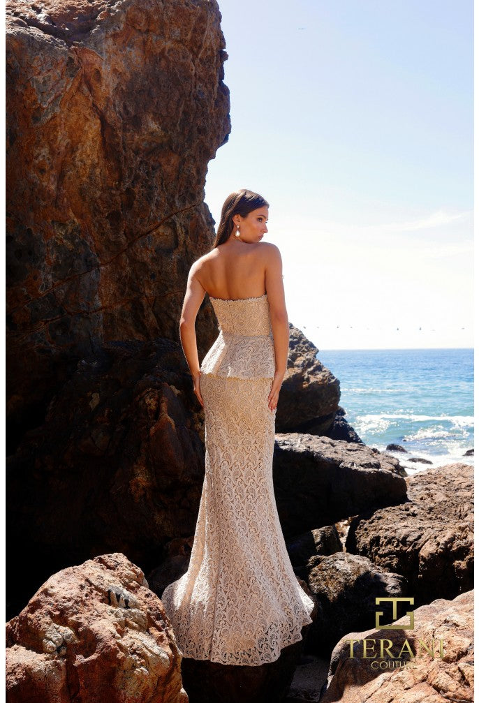 Model wearing Terani Couture 252E5144 strapless lace gown with peplum waist and fit and flare silhouette.