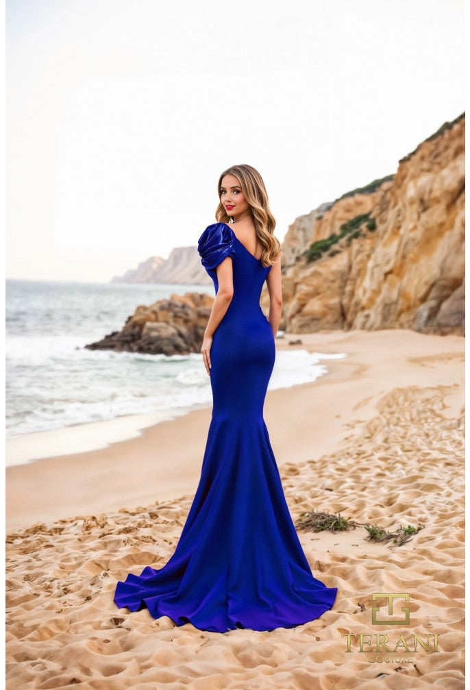 Model wearing Terani Couture 252E5514 one-shoulder gown with puff sleeve, draped bodice, and chapel train in the color royal.  Back View.