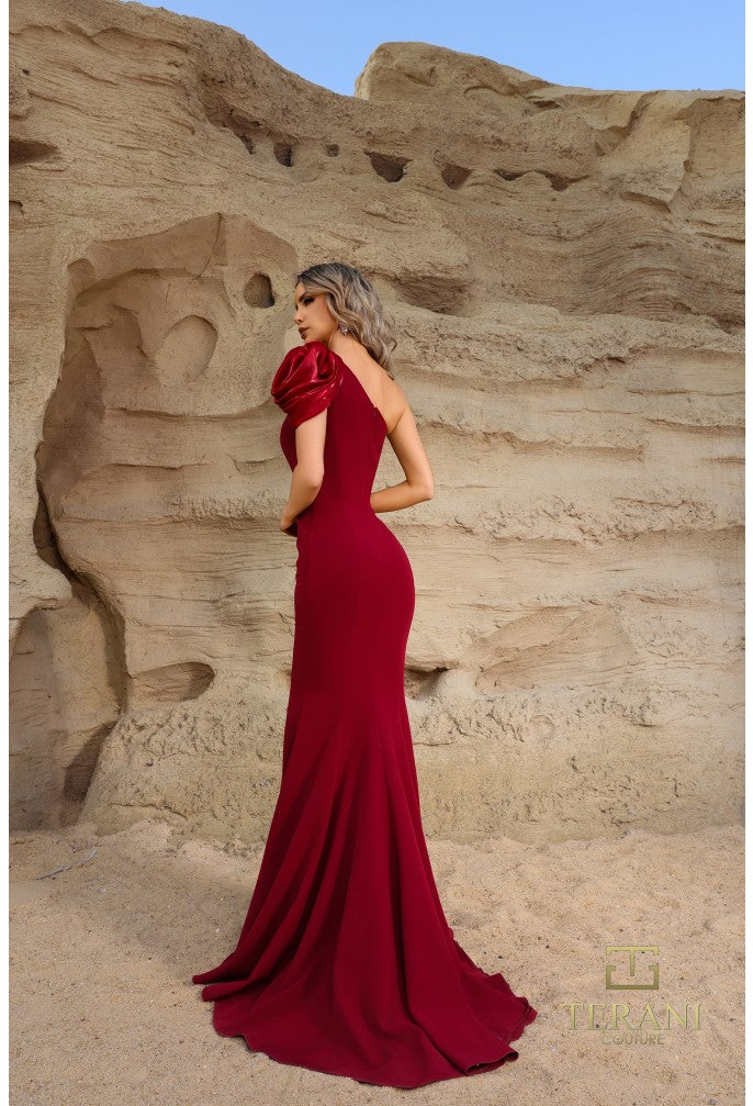 Model wearing Terani Couture 252E5514 one-shoulder gown with puff sleeve, draped bodice, and chapel train in the color wine.