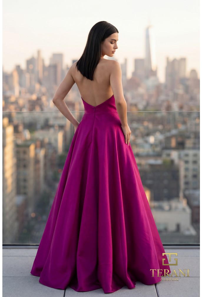 Model wearing Terani Couture 261E6544 strapless evening gown featuring a structured bodice, floral appliqué detailing, and a flowing floor-length skirt.