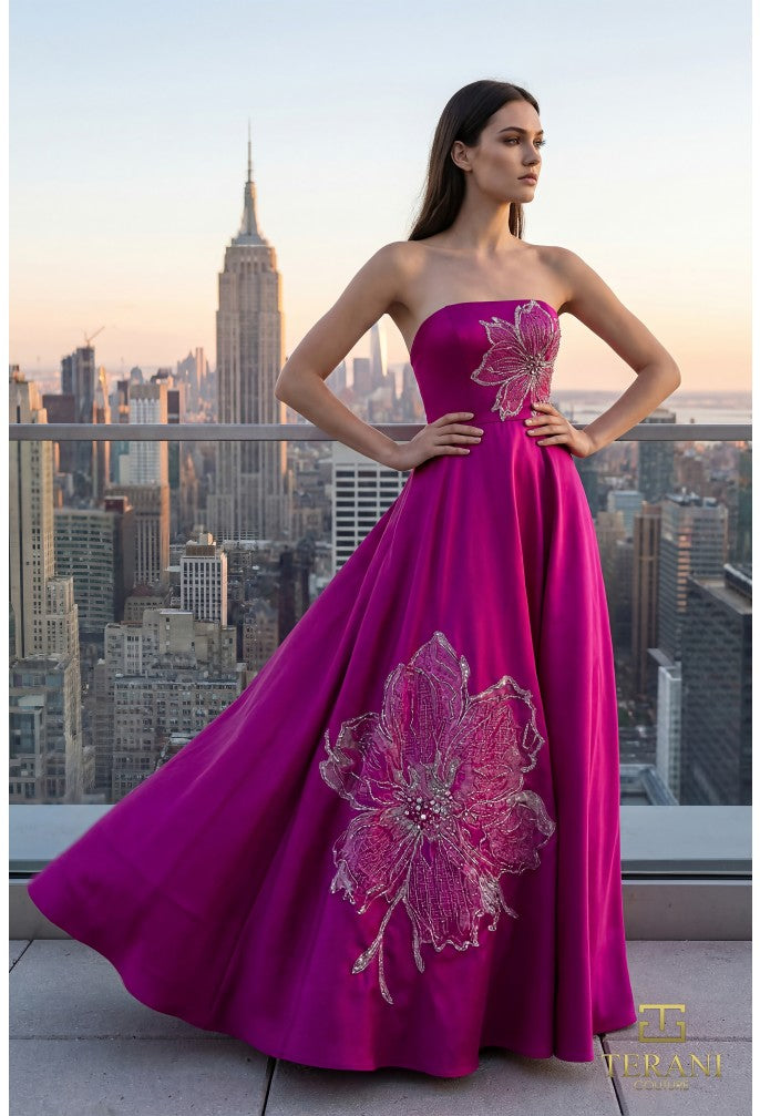 Model wearing Terani Couture 261E6544 strapless evening gown featuring a structured bodice, floral appliqué detailing, and a flowing floor-length skirt.