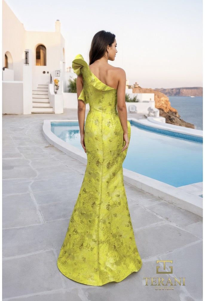 Woman in a yellow one-shoulder dress standing by a pool with a scenic background