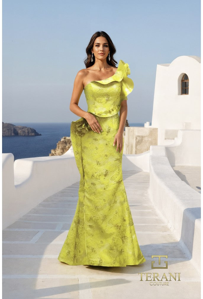Model wearing Terani Couture 261E6678 one-shoulder mermaid gown with sculpted ruffles and side drape detail, standing on a sunlit terrace overlooking the sea.